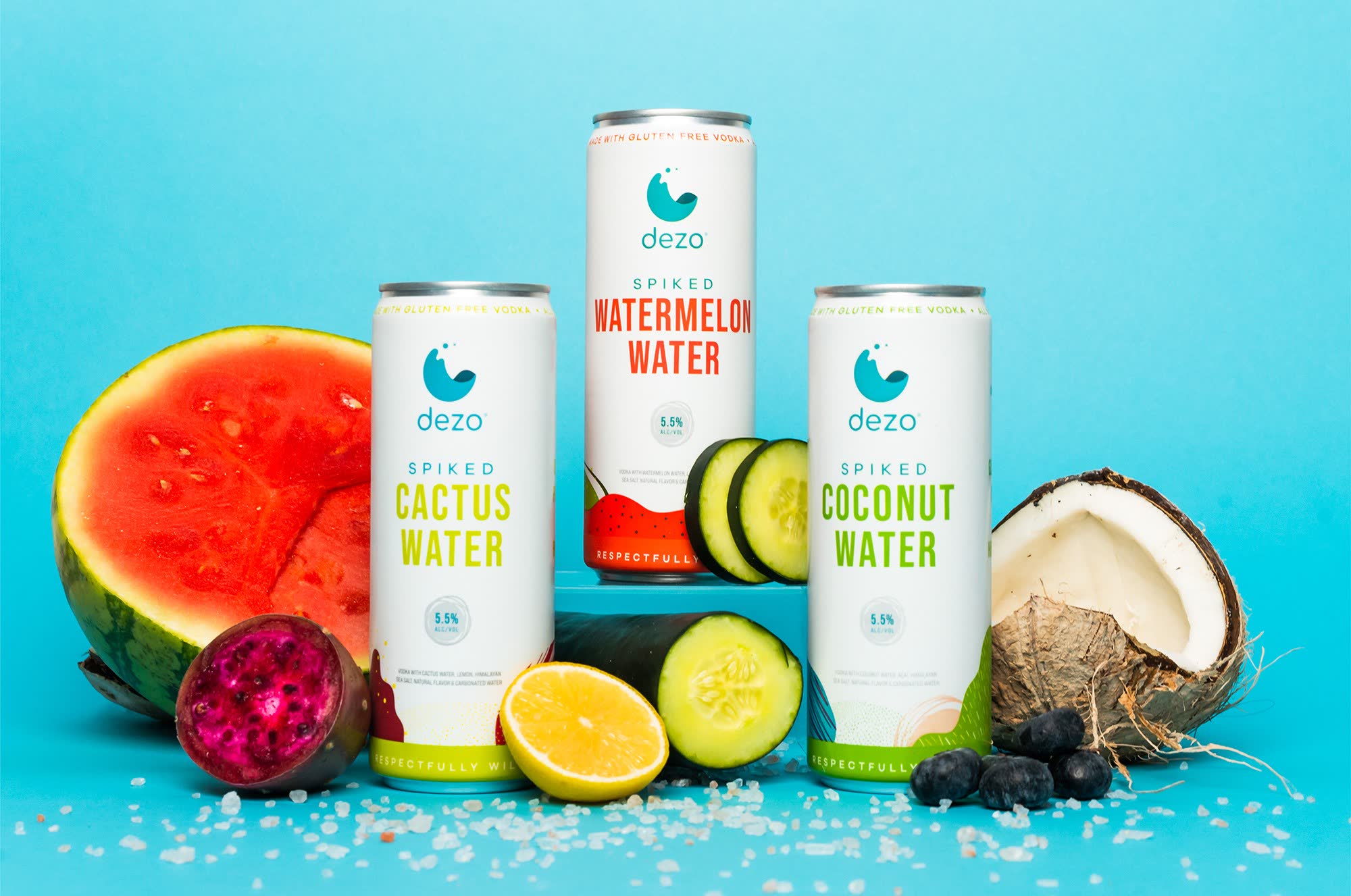 Dezo's three spiked fruit water flavors styled with fresh fruit on a blue background